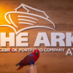 Eclectus parrot in front of ARK logo